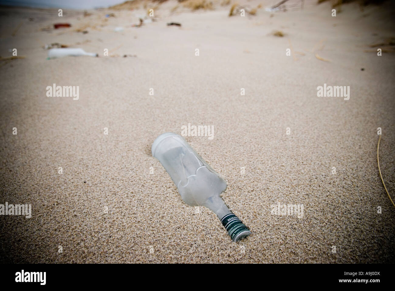Frosted vodka bottle washed ashore on the Baltic coast beach of Curonian Spit Lithuania Stock Photo