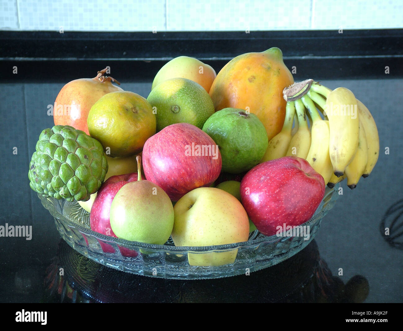 Fruit bowl with Apple Pomegranate Papaya Custard apple Bananas Pear Orange fruits Stock Photo