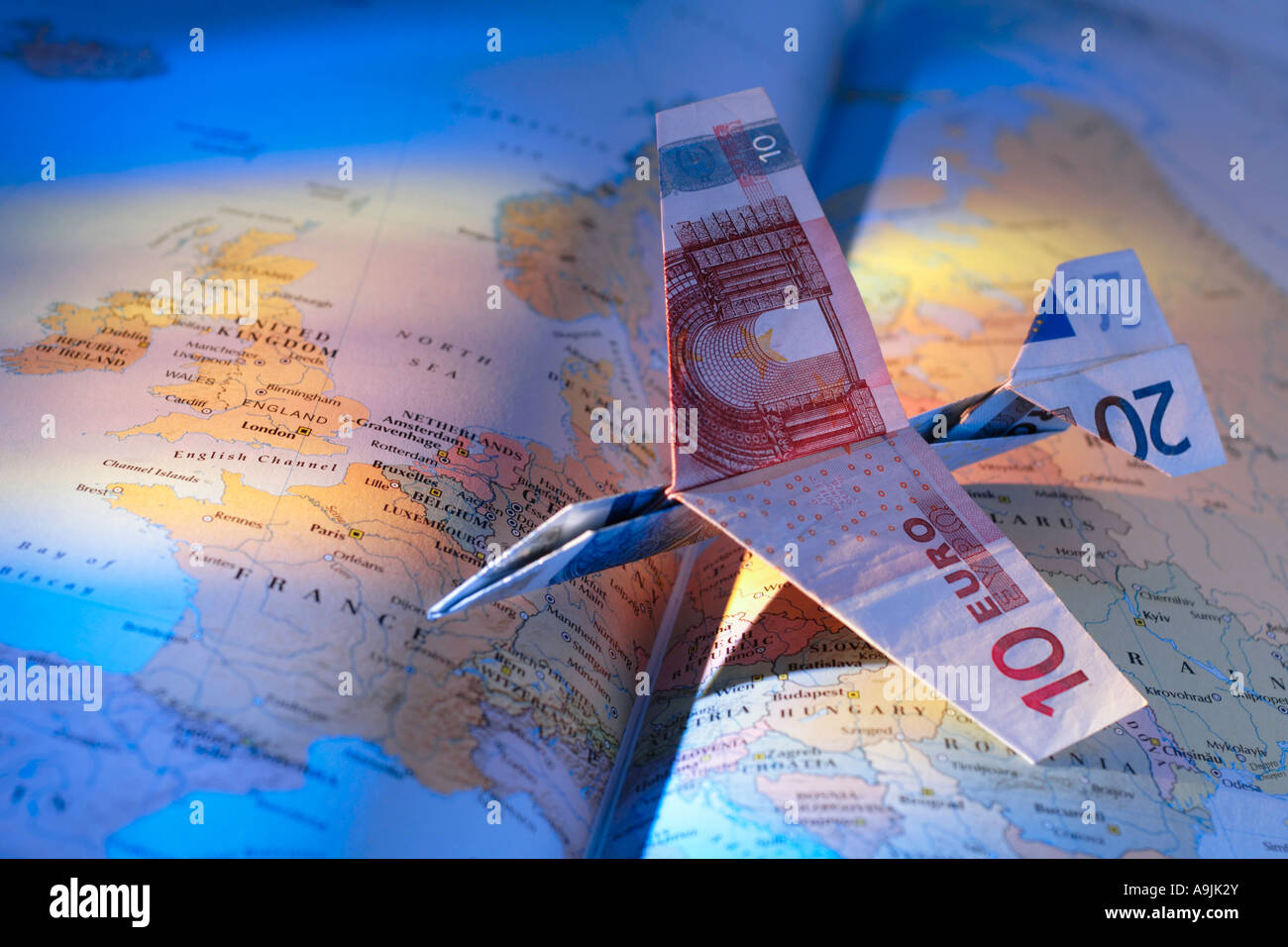 airplane made of Euro notes on open atlas Stock Photo