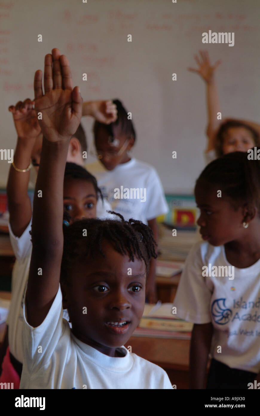 Children with raised hands inside the classroom Stock Photo - Alamy