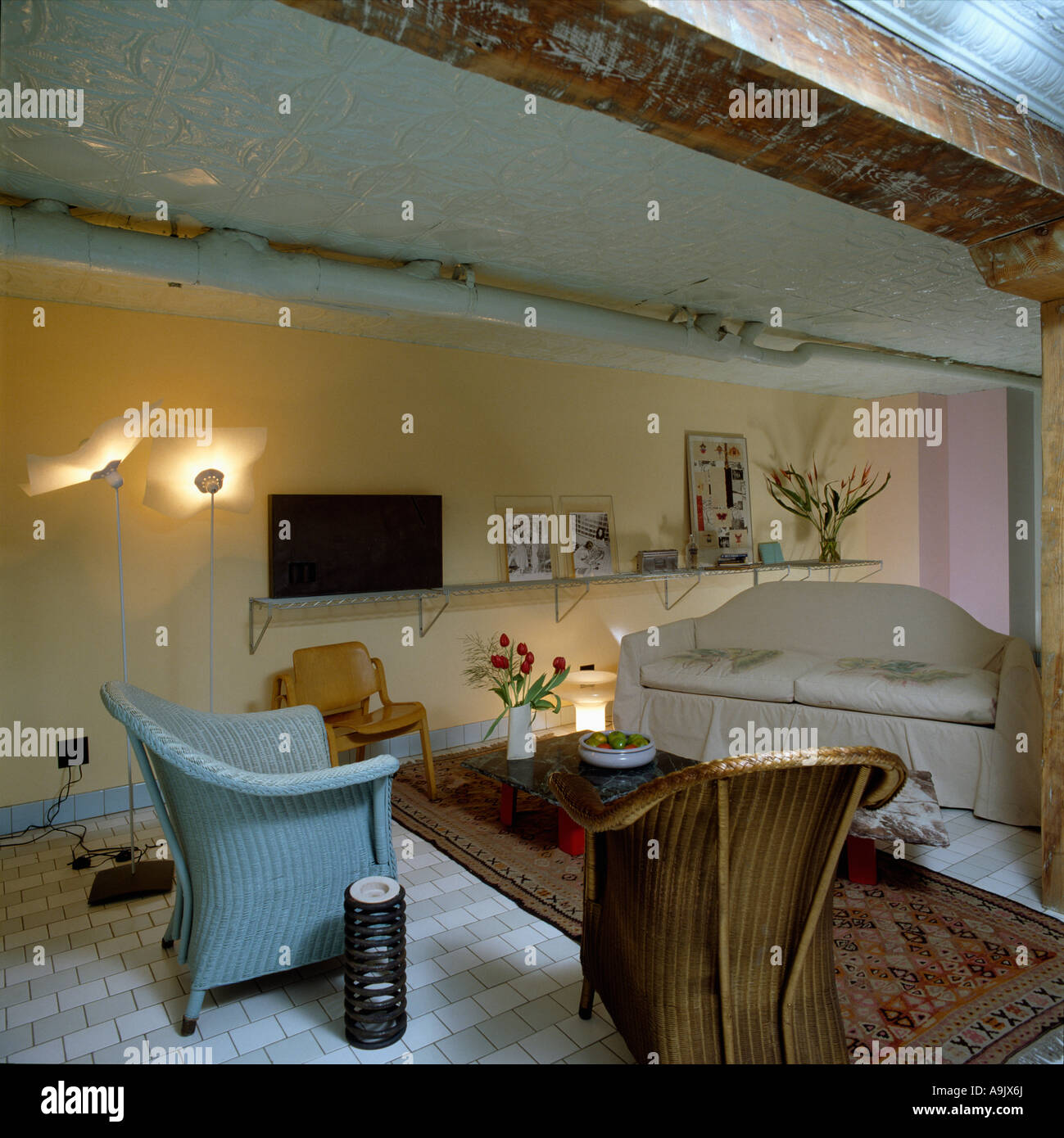 Lloyd Loom chairs and beige sofa in loft conversion sitting room Stock