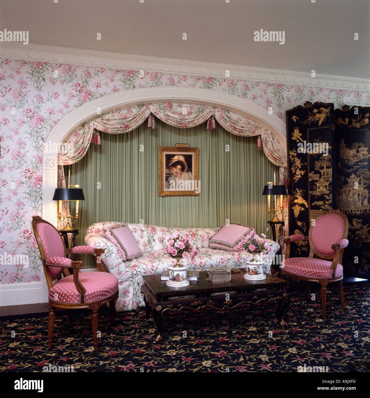 Pink floral sofa in alcove with green drapes in eighties living room with pink  floral wallpaper Stock Photo - Alamy