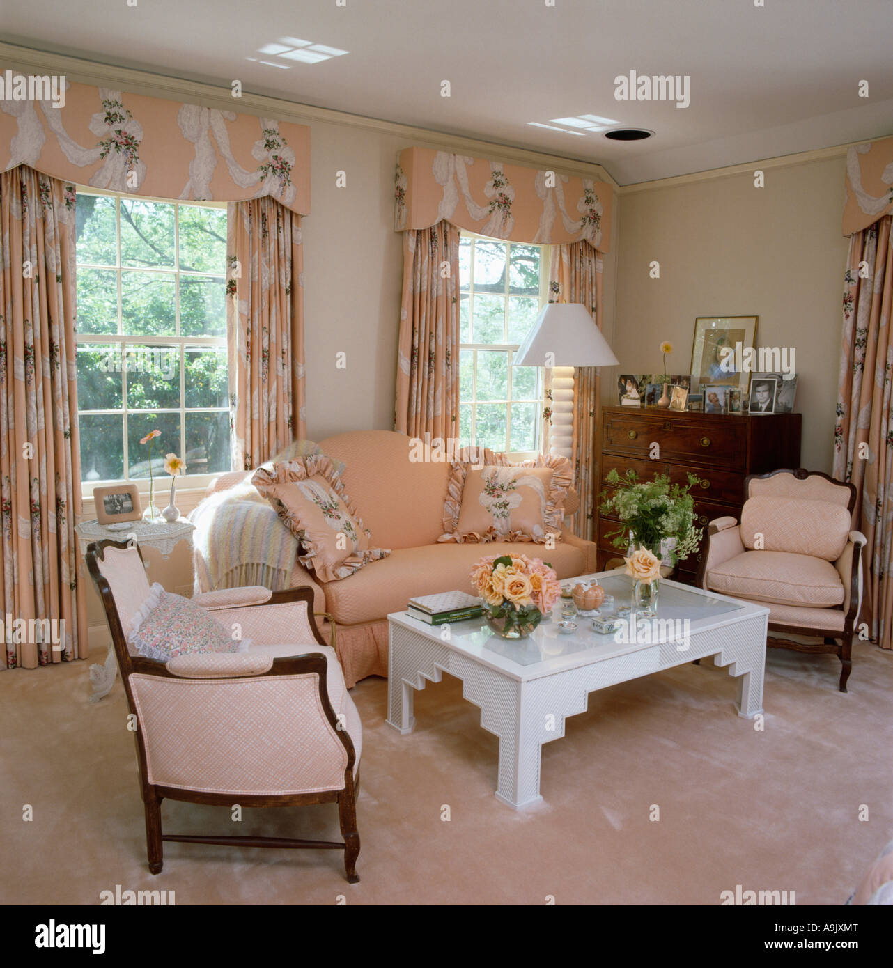 Peach sofa and patterned curtains with pelmets in peach eighties livingroom  with white table and peach carpet Stock Photo - Alamy