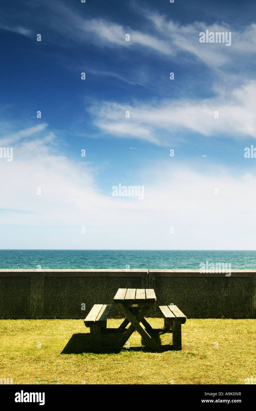 an empty picnic bench by the sea Stock Photo