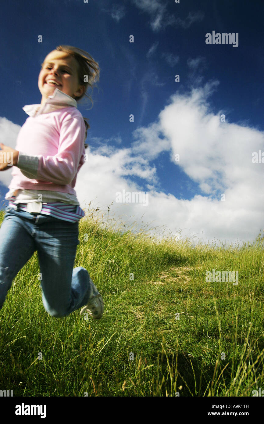 a young girl running down a hill Stock Photo, Royalty Free Image ...