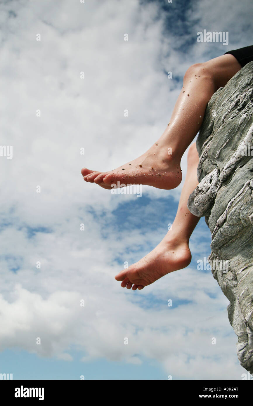 feet dangling from rock Stock Photo Alamy