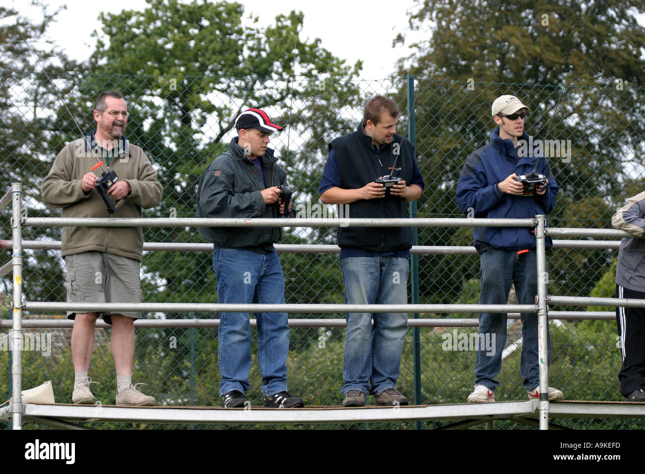 A group of model racing car enthusiasts race their remote control vehicles around a race track