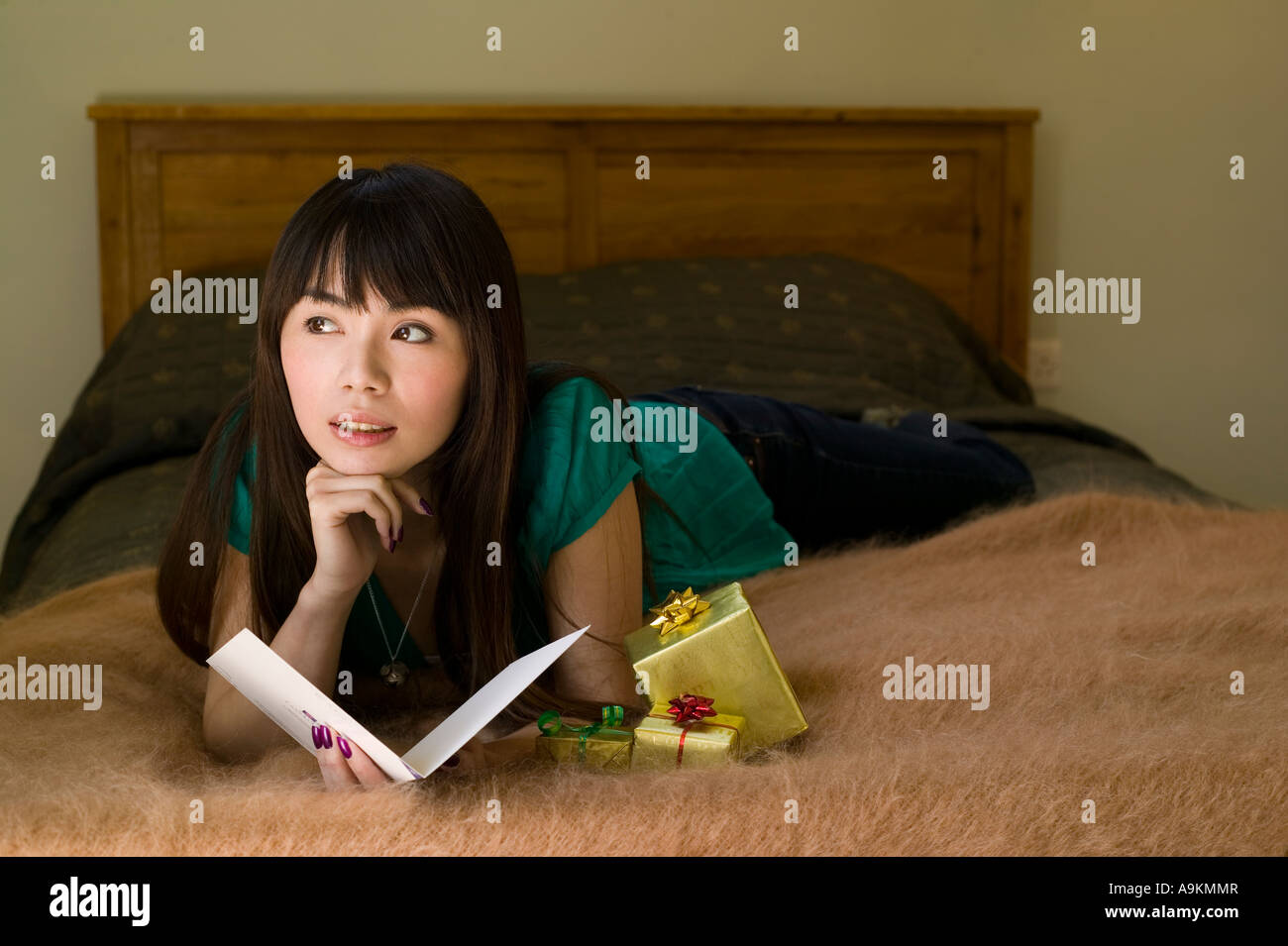 young woman at home with a greetings card and presents Stock Photo - Alamy