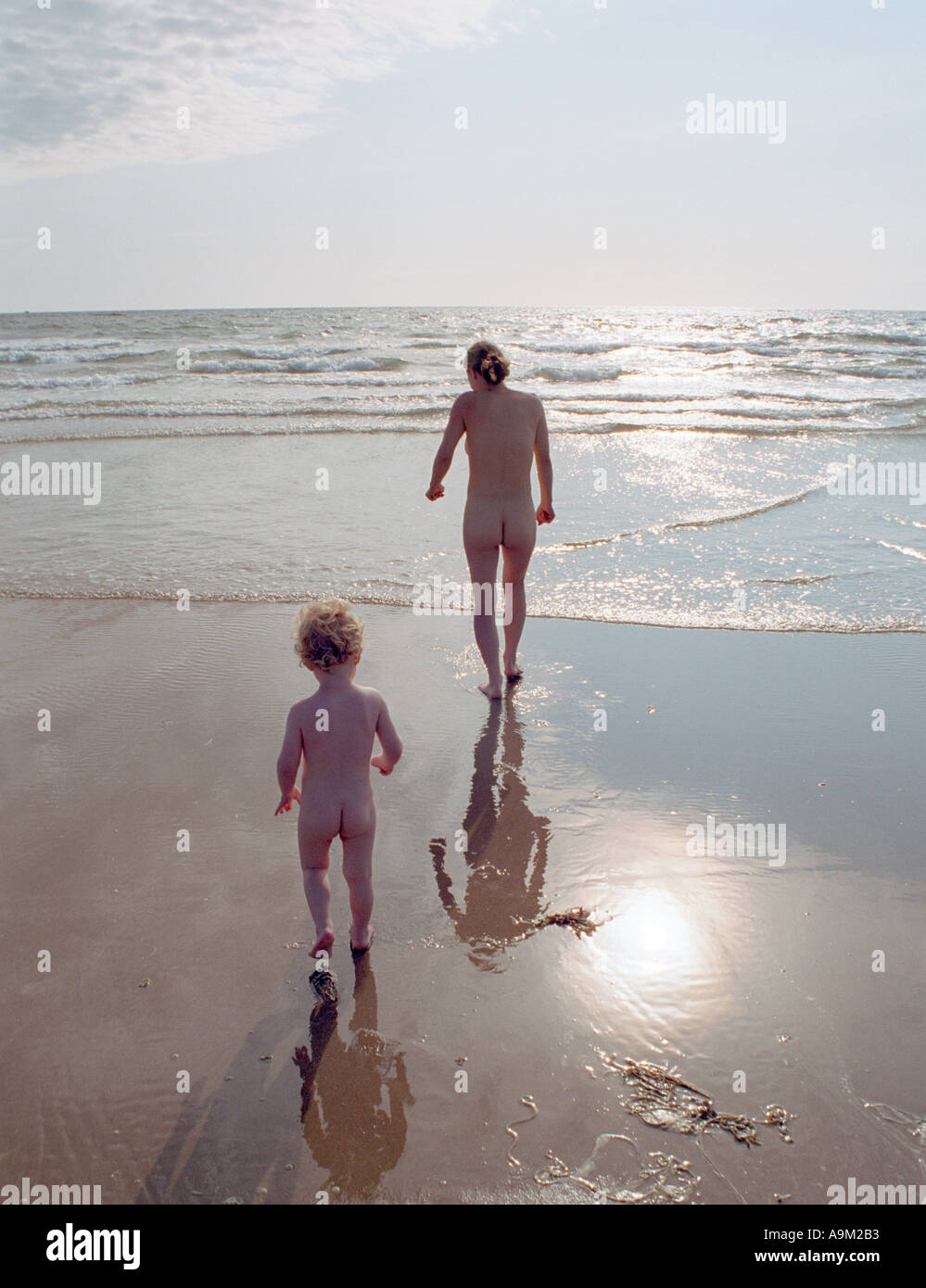 mother and son going for a nude swim in the sea by Aberdyfy Aberdovey North West Wales Stock Photo