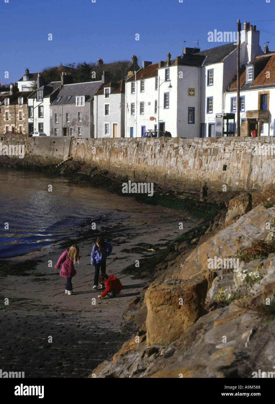 dh  ST MONANCE FIFE Scotland children on harbour sandy beach houses seafront kids playing uk monans outdoors britain Stock Photo