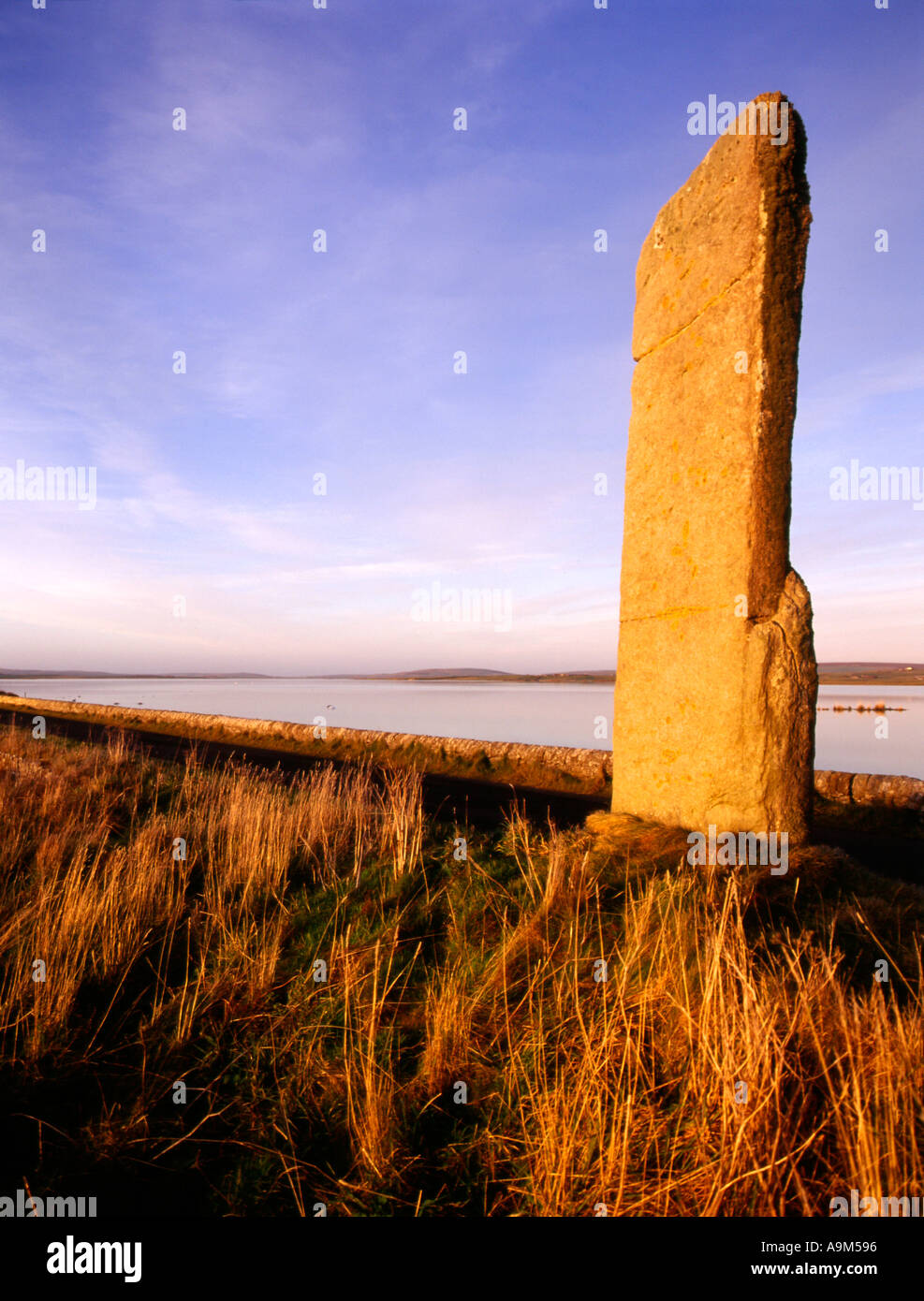 dh Watch stone STENNESS ORKNEY Neolithic standing stone causeway Loch of Harray at dusk ancient scotland Stock Photo