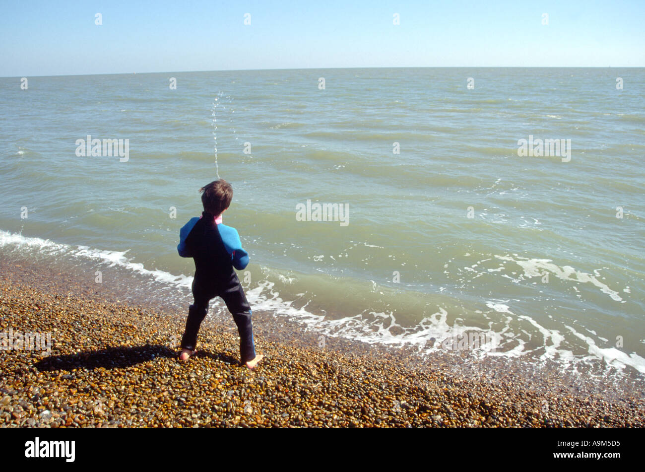 Boy pretending to urinate spraying water into the sea from beach Stock Photo 2295252 Alamy