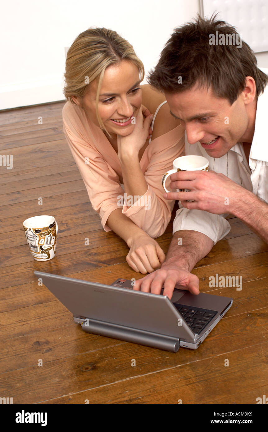 couple using a laptop while drinking coffee Stock Photo