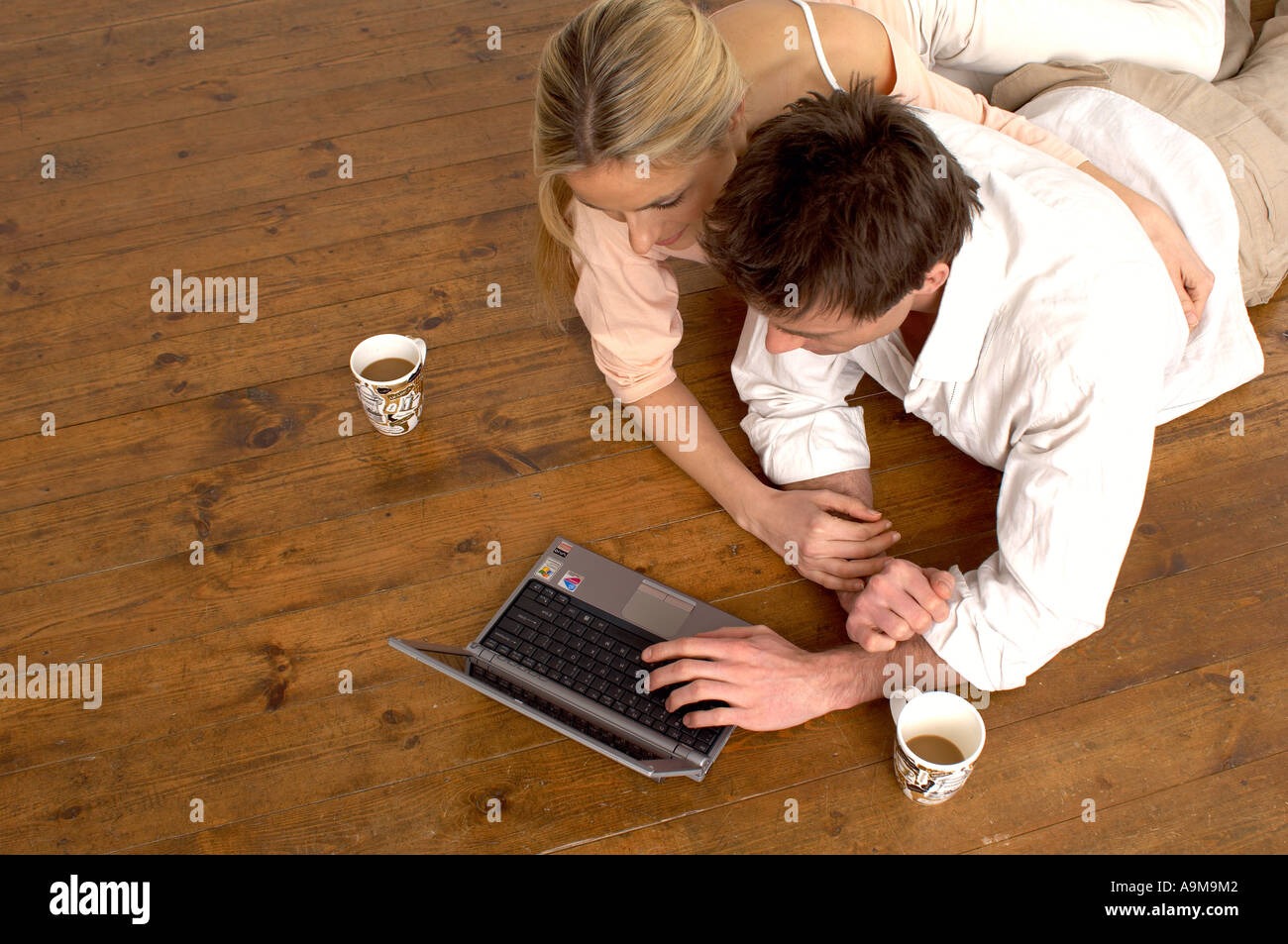 couple using a laptop while drinking coffee Stock Photo