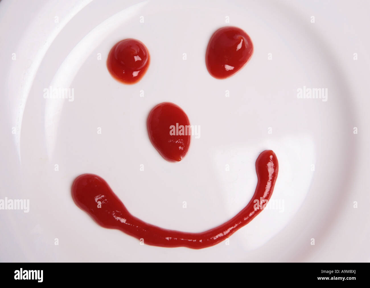 tomato sauce face on childs plate Stock Photo Alamy