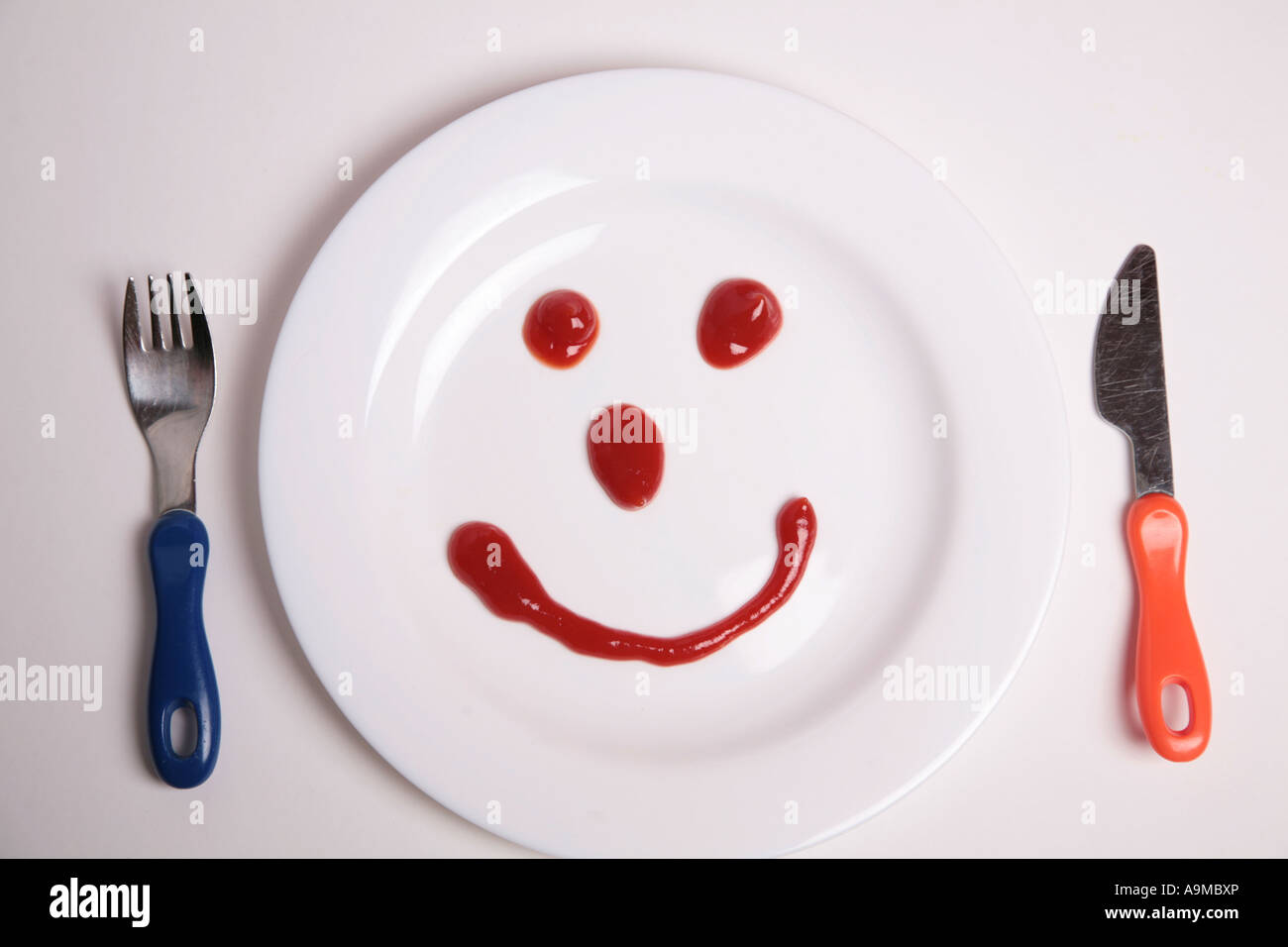 tomato sauce face on childs plate Stock Photo Alamy