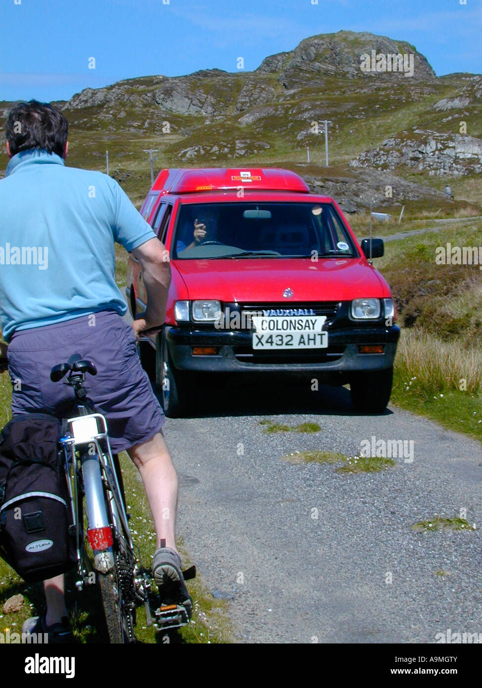 Male cyclist giving way to the post office van on a single track road on the island of Colonsay Inner Hebrides Scotland Stock Photo