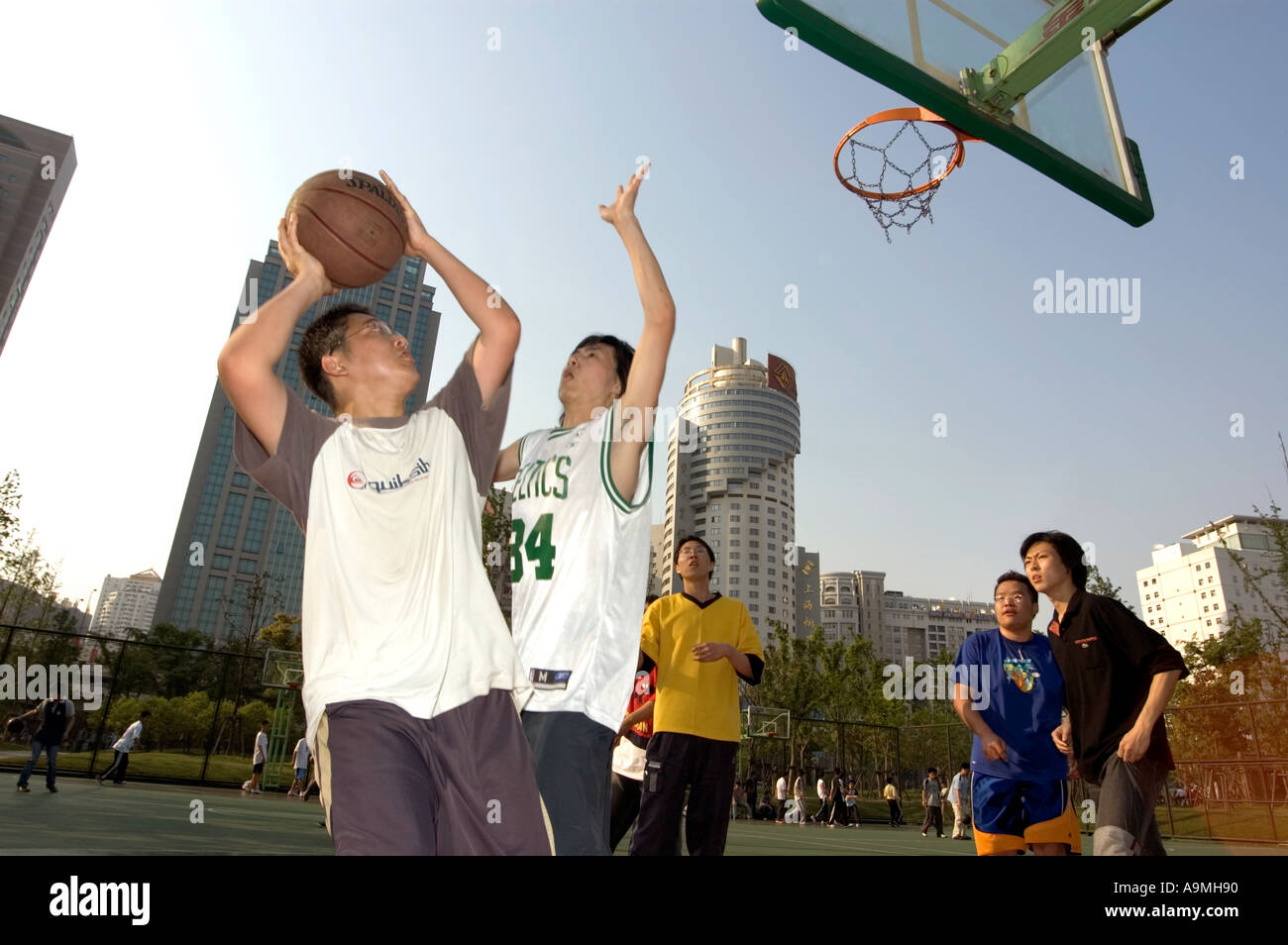 YOUNG PEOPLE PLAYING BASKETBALL IN DOWNTOWN SHANGHAI CHINA Stock Photo