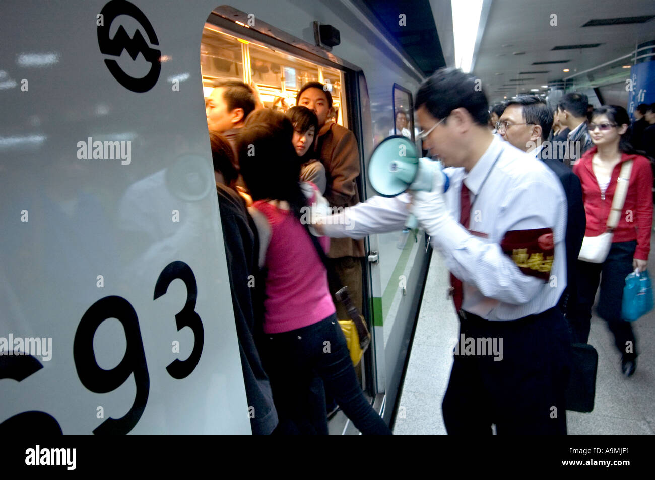MAN WITH MEGAPHONE PUSH COMMUTERS INTO CROWDED TRAIN SO DOORS WILL CLOSE  RUSH HOUR AT PEOPLE S SQUARE SHANGHAI CHINA Stock Photo - Alamy