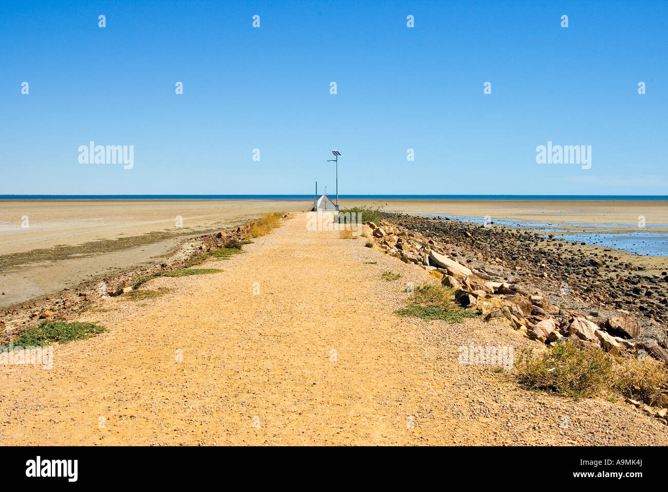 view of the beach rocks and seashore approaching the jetty at port