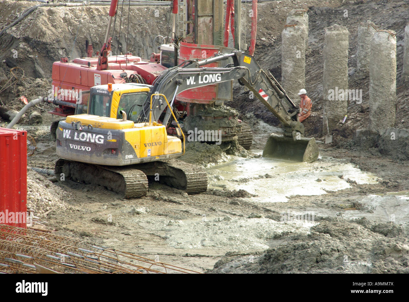 Construction site mechanical excavator working alongside pile boring