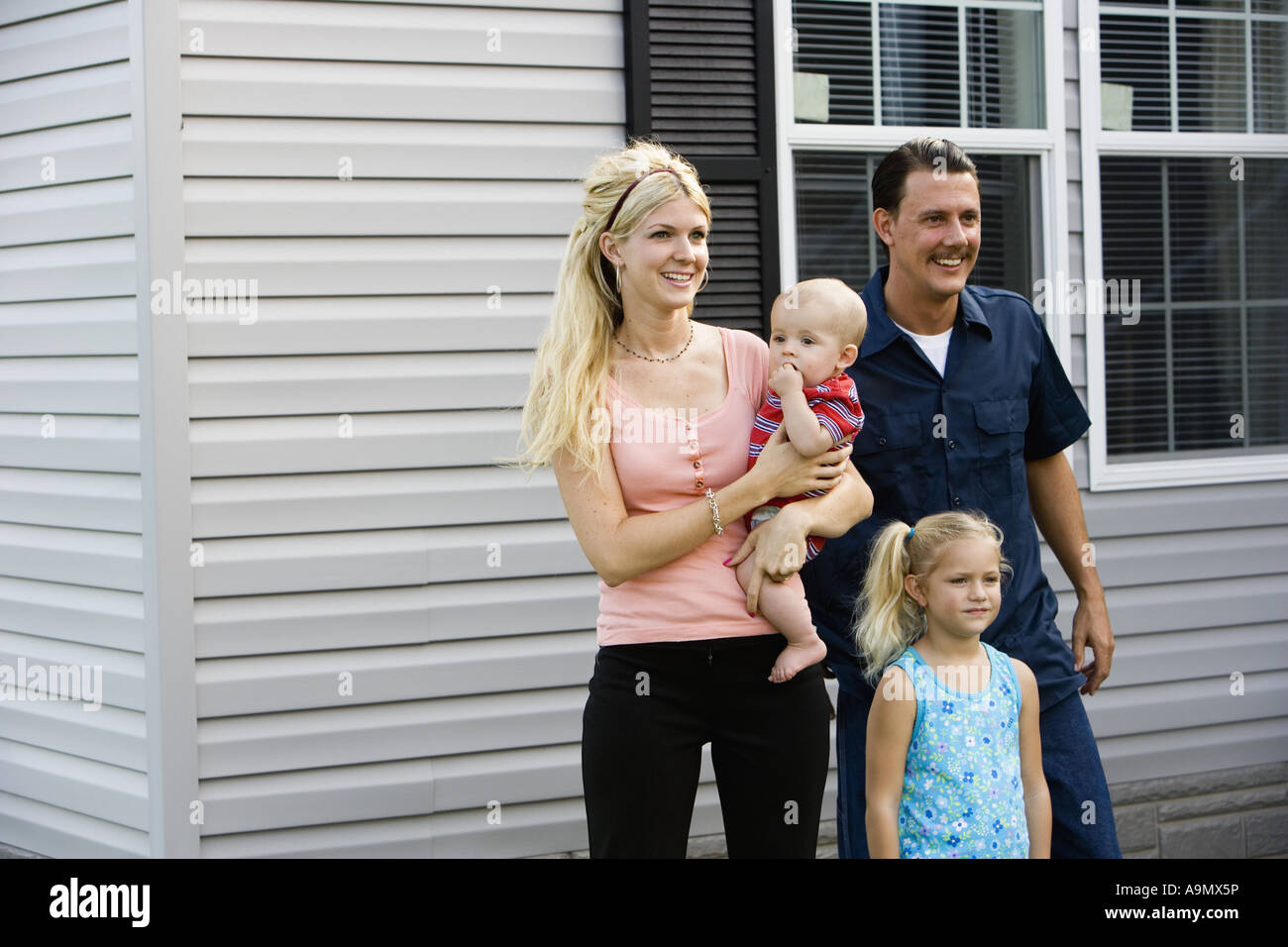 A family standing together outside their home Stock Photo - Alamy
