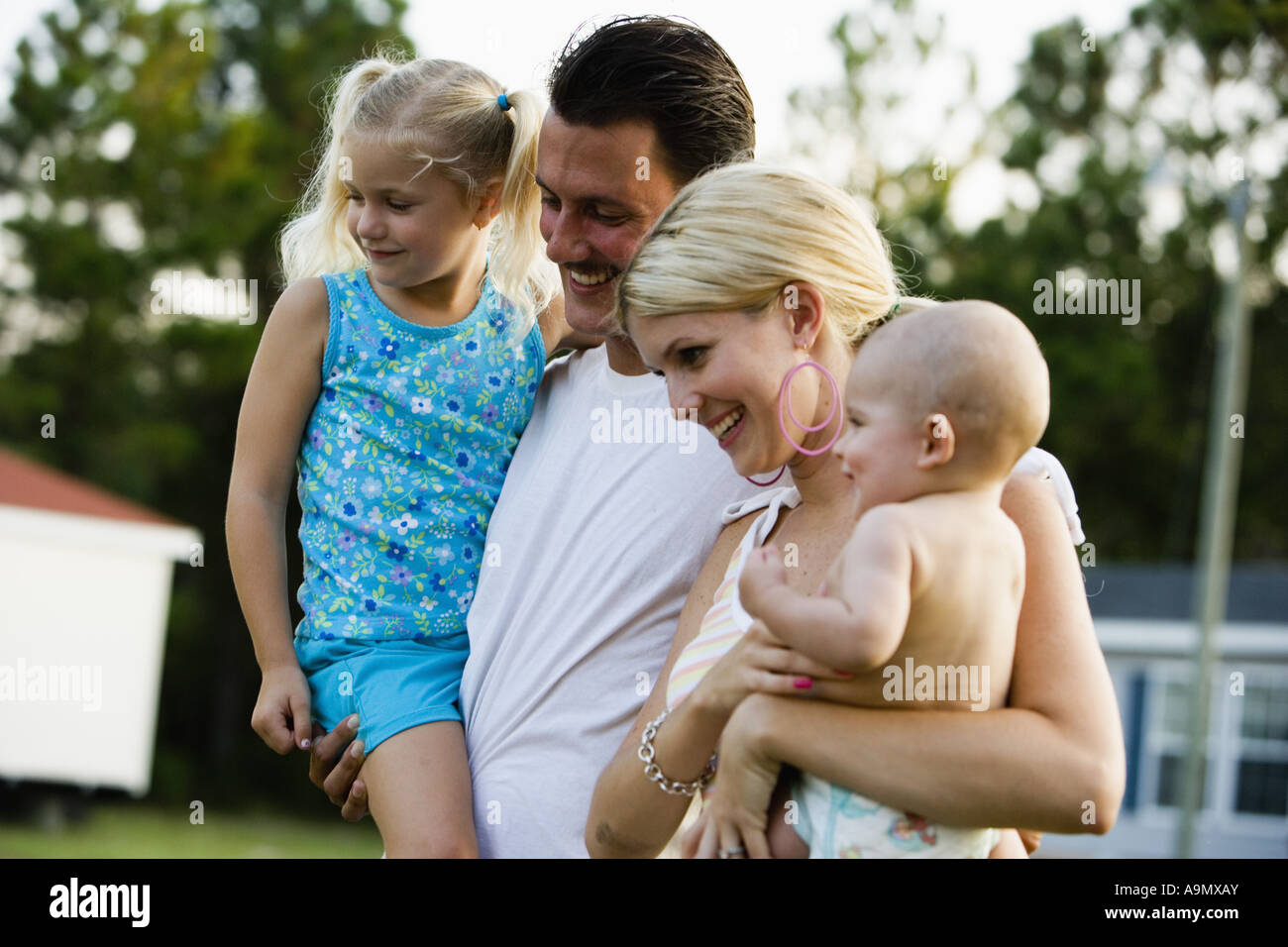 Young family standing outside Stock Photo - Alamy