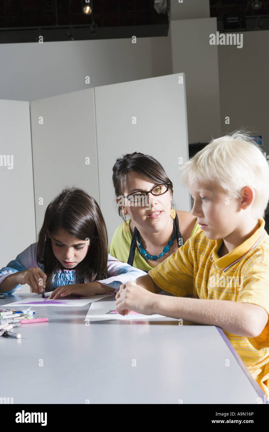 An art teacher teaching young students in art class Stock Photo - Alamy