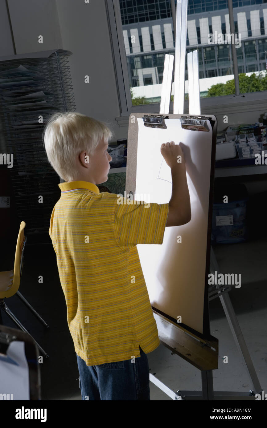 A boy drawing on an easel in art class Stock Photo Alamy