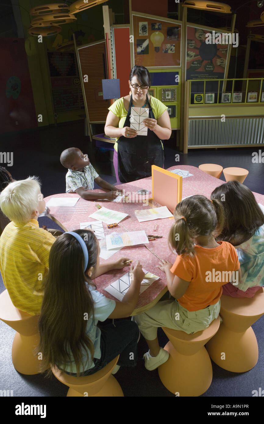 An art teacher teaching her young students in art class Stock Photo - Alamy