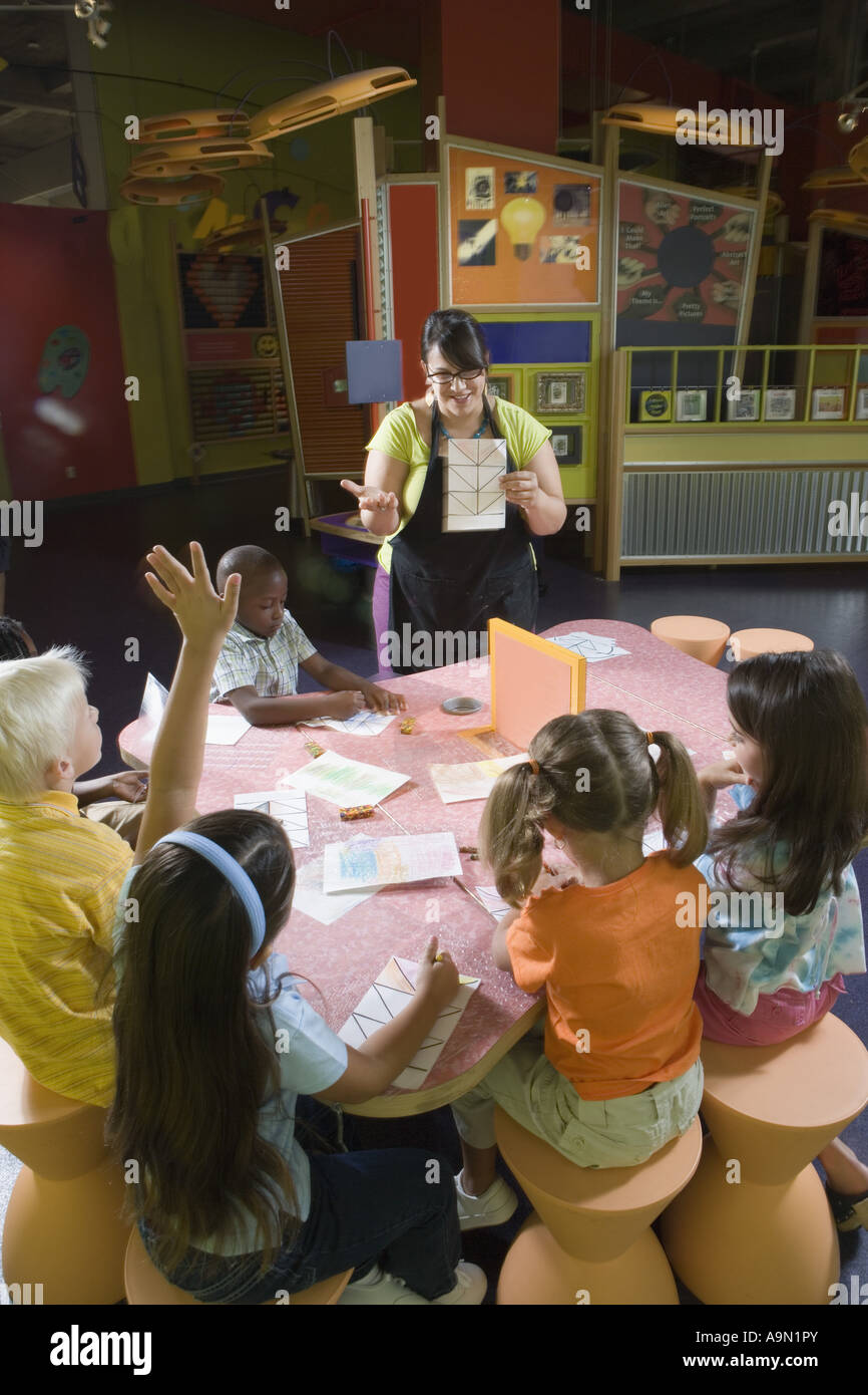An art teacher teaching her young students in art class Stock Photo - Alamy