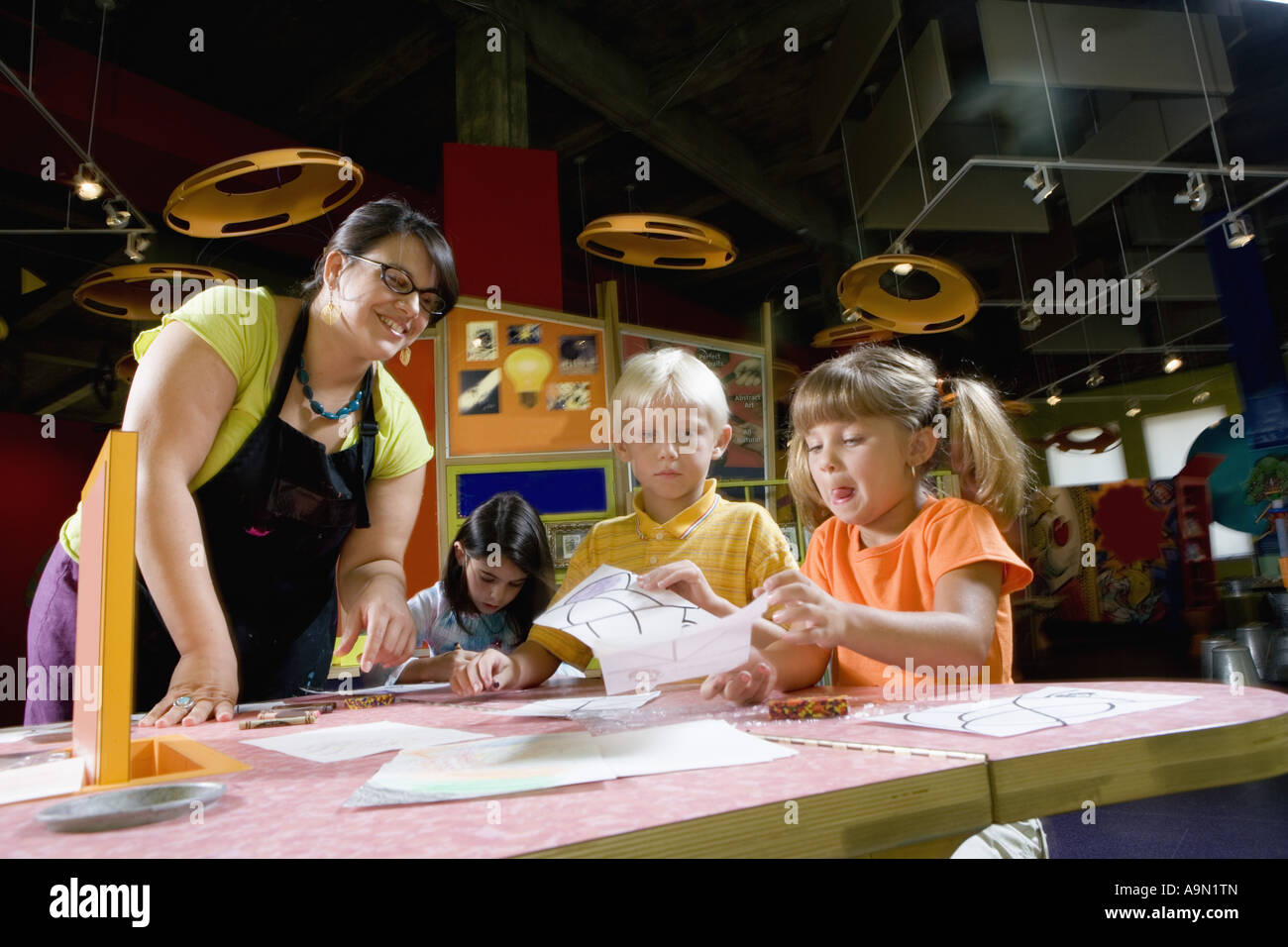 An art teacher teaching her young students in art class Stock Photo - Alamy