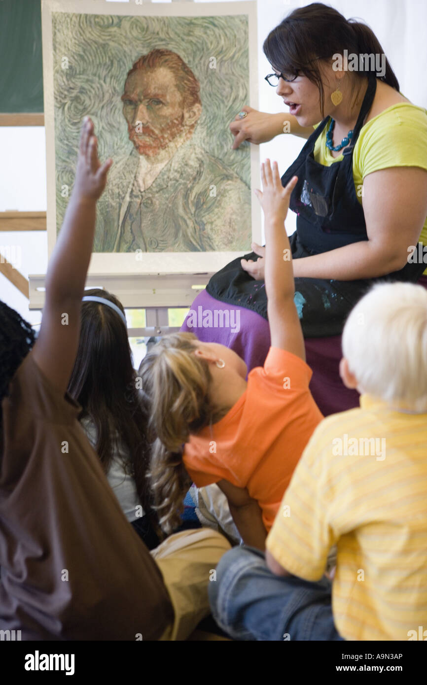 An art teacher showing painting to young students in art class Stock ...