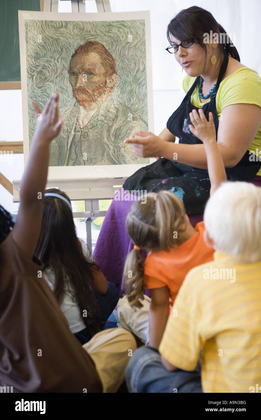 An art teacher showing painting to young students in art class Stock ...