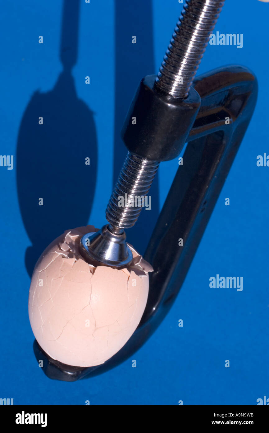 Pressure crush broken egg being crushed with clamps Stock Photo Alamy