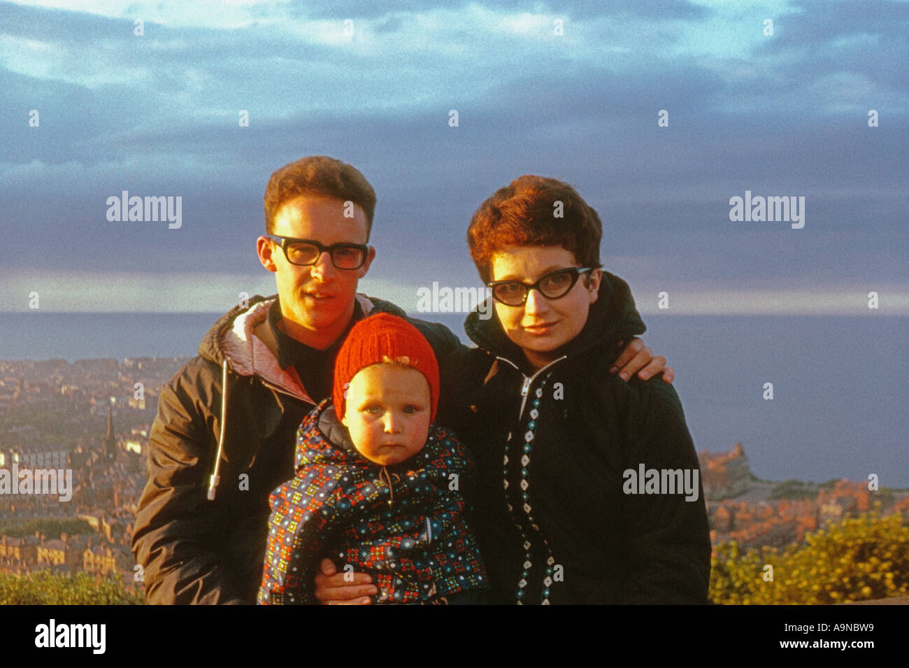 Young Caucasian family in warm coats at Oliver's Mount with Scarborough and the North Sea in the distance. Circa 1960. Archive Stock Photo