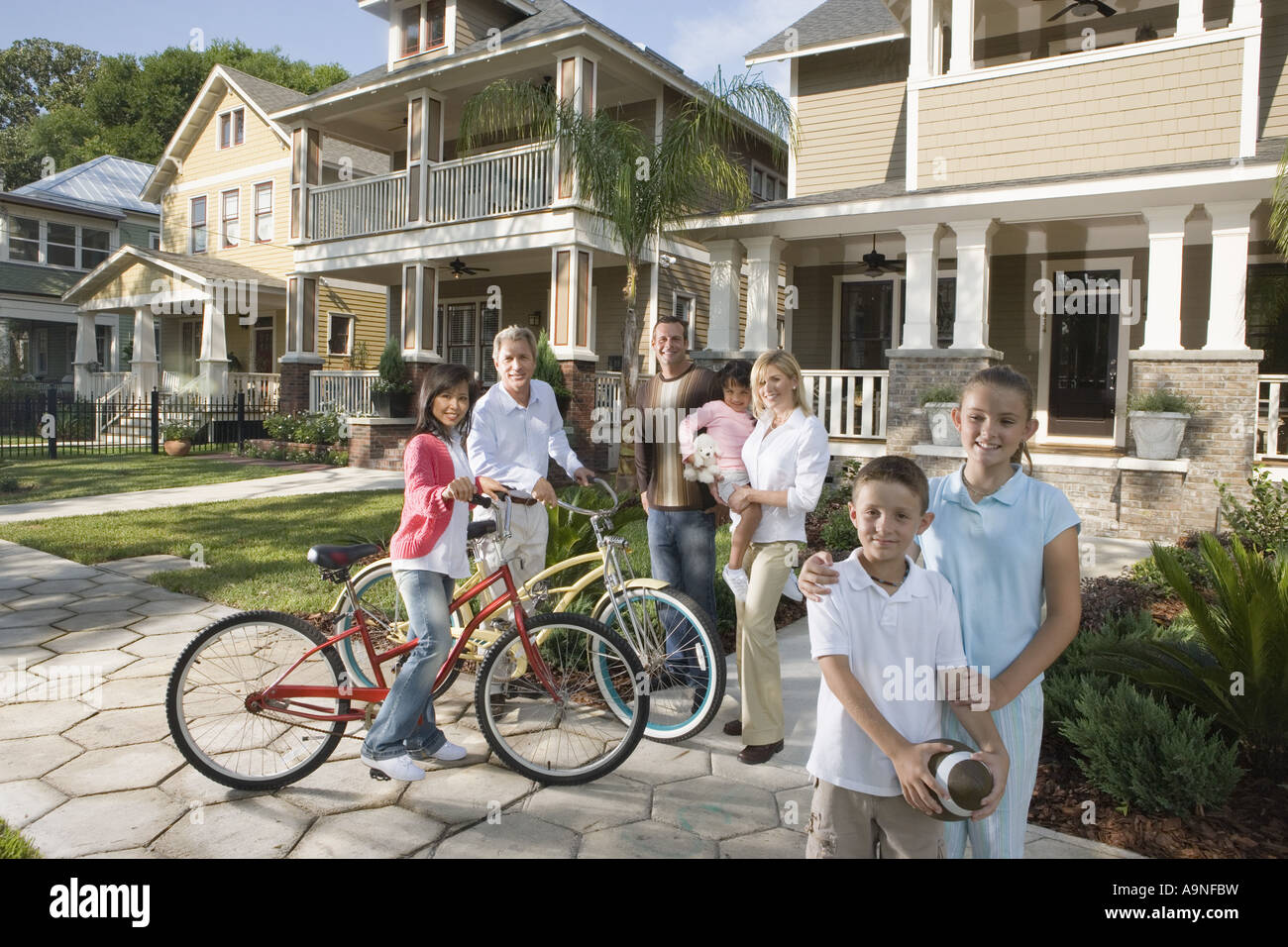 Family with young children standing with neighbors in front of house Stock Photo