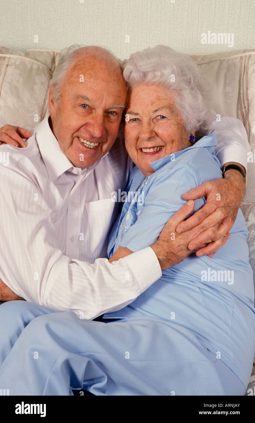 portrait happy mature octogenarian couple hugging on sofa Stock Photo