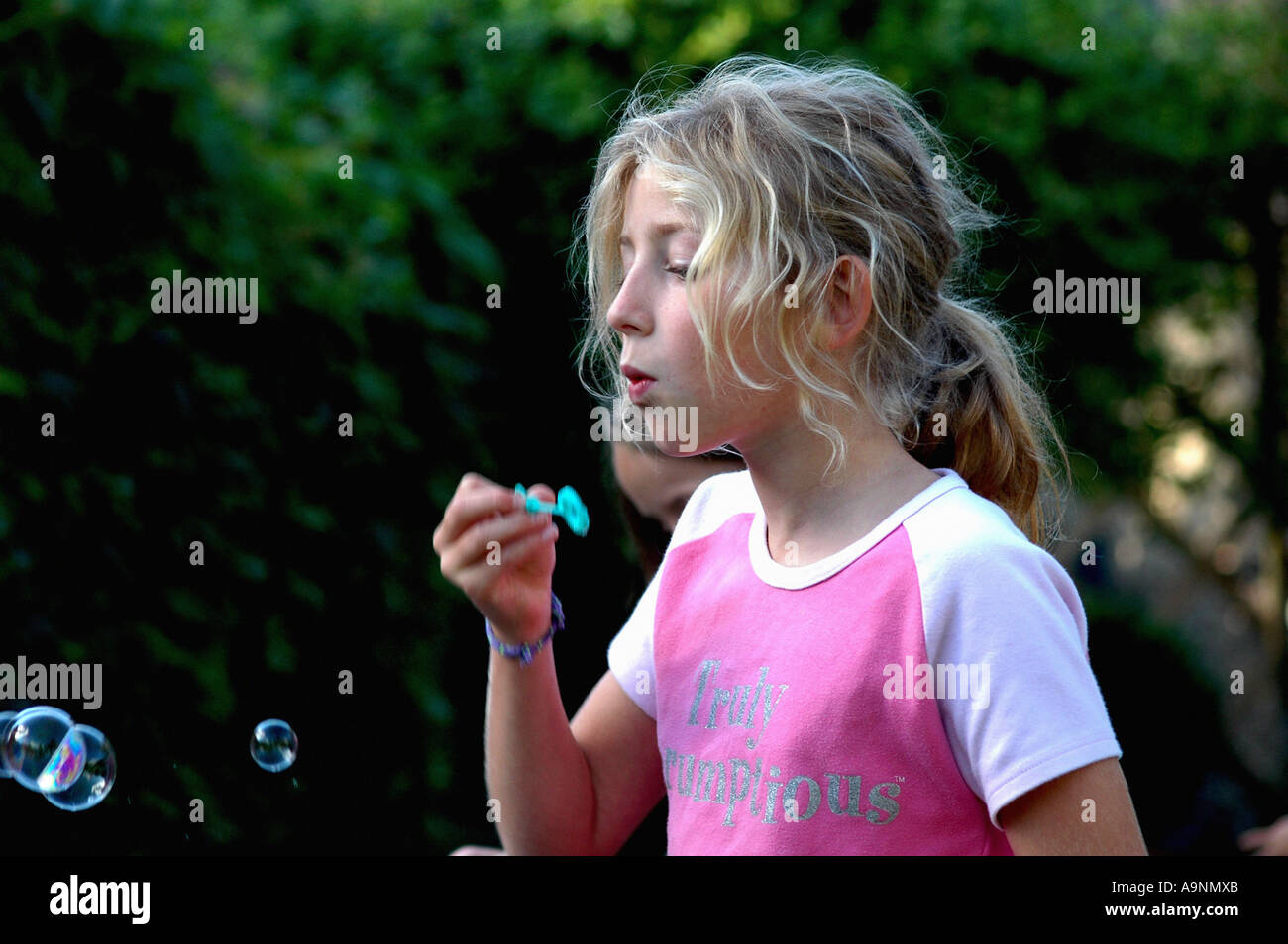 young girl blowing bubbles outside Stock Photo