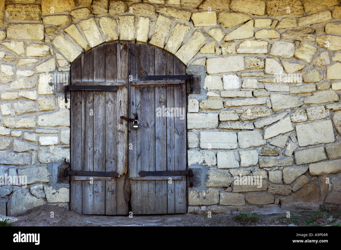 Old stone wall with an arched wooden door texture Stock Photo - Alamy