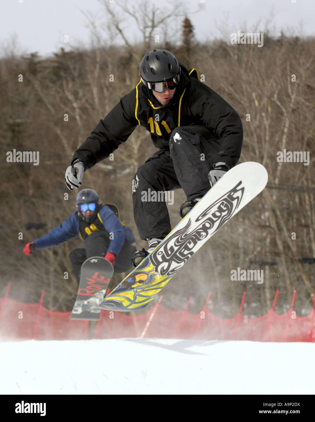 Two Snowboarders racing mid-air during a boardercross competition Stock Photo