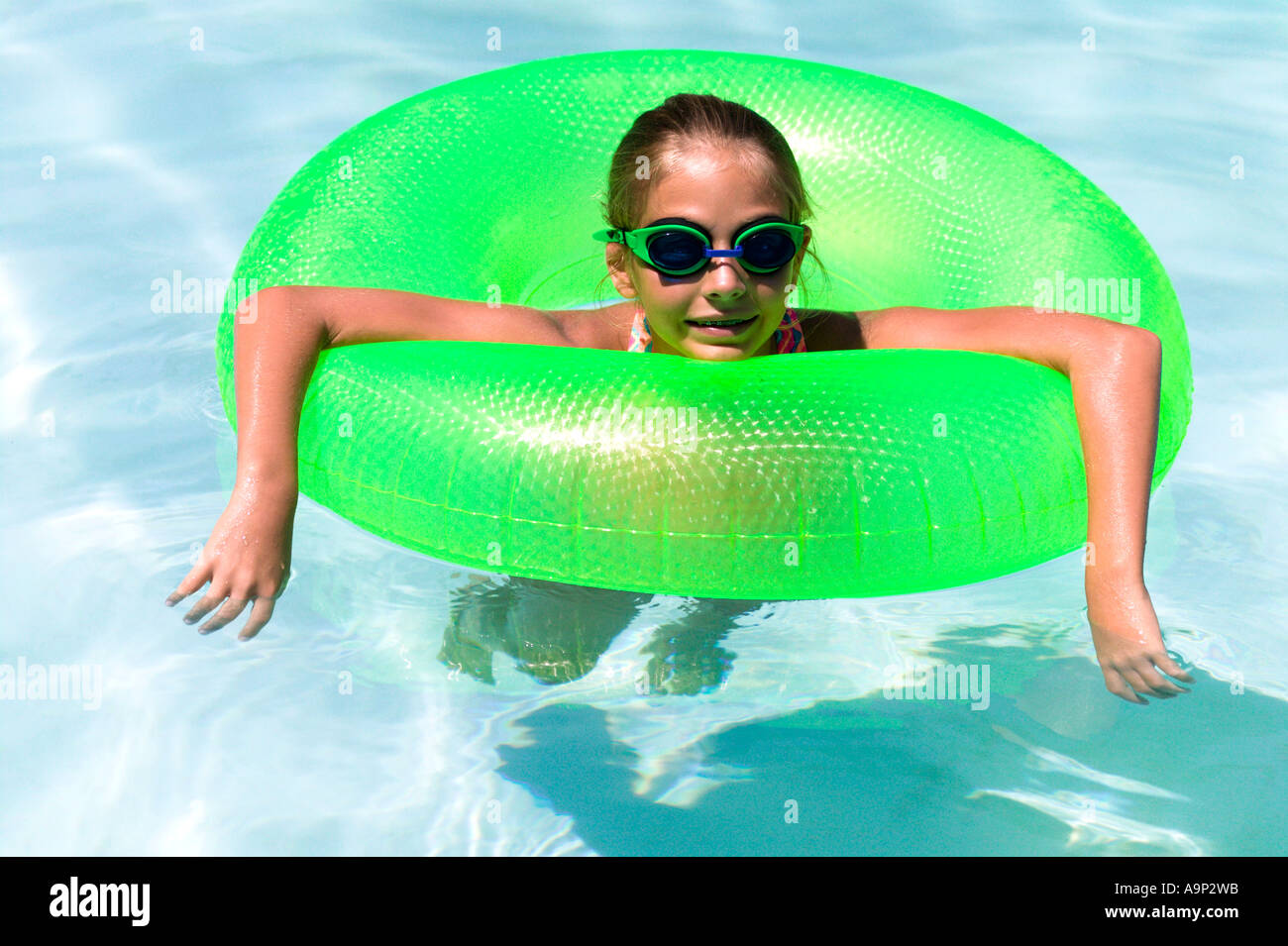 Girl floating in inner tube in pool Stock Photo - Alamy