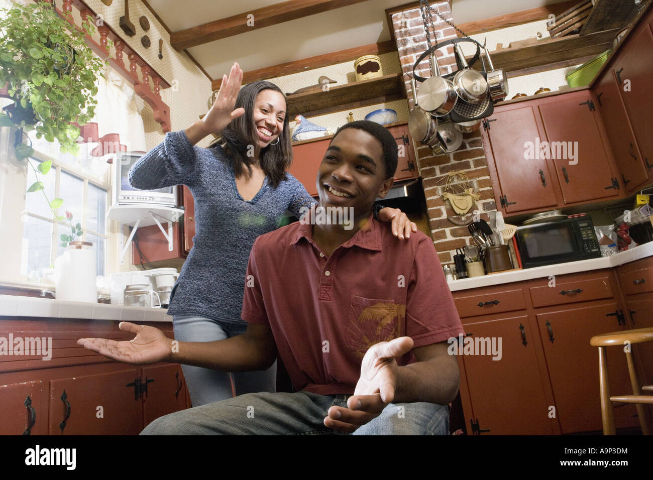 African American brother and sister laughing in kitchen Stock Photo