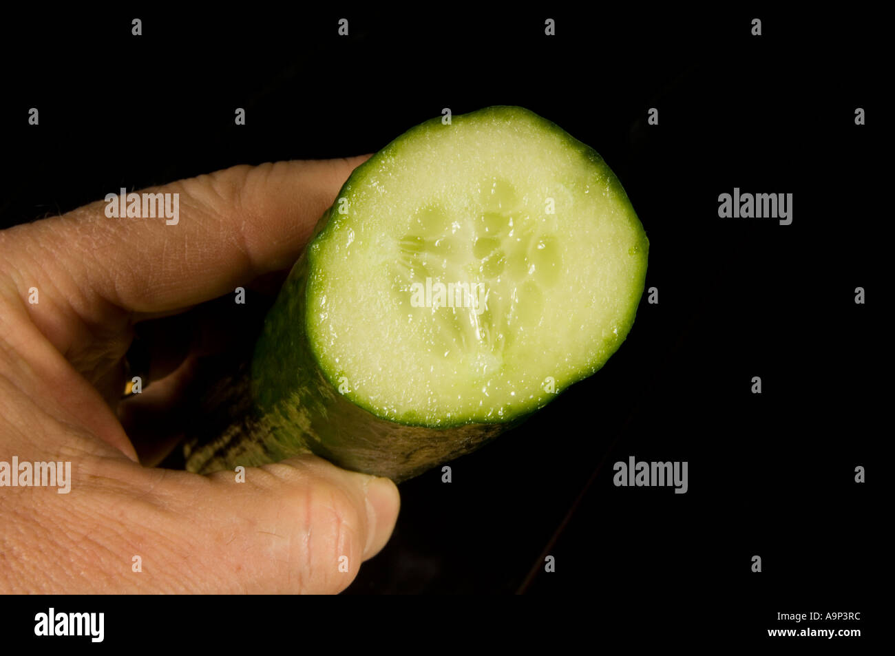 Hand holding a cucumber Stock Photo