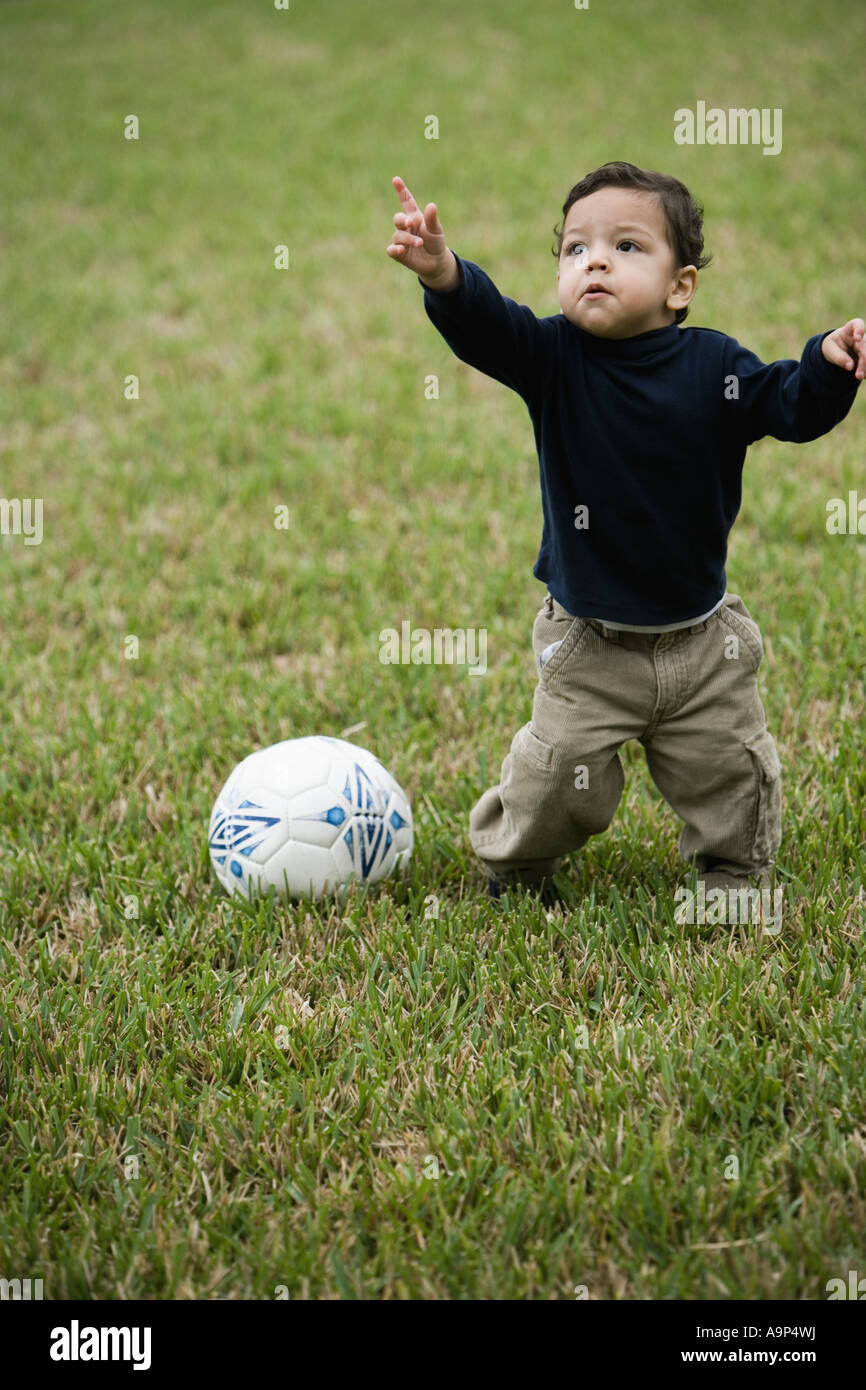 Little Hispanic boy on grass with soccer ball Stock Photo - Alamy