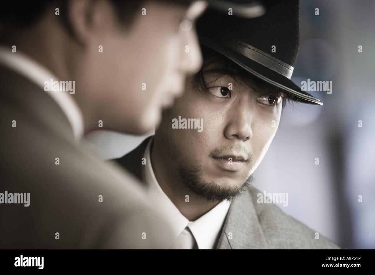 Close-up of two young Asian men wearing suits and hats Stock Photo - Alamy
