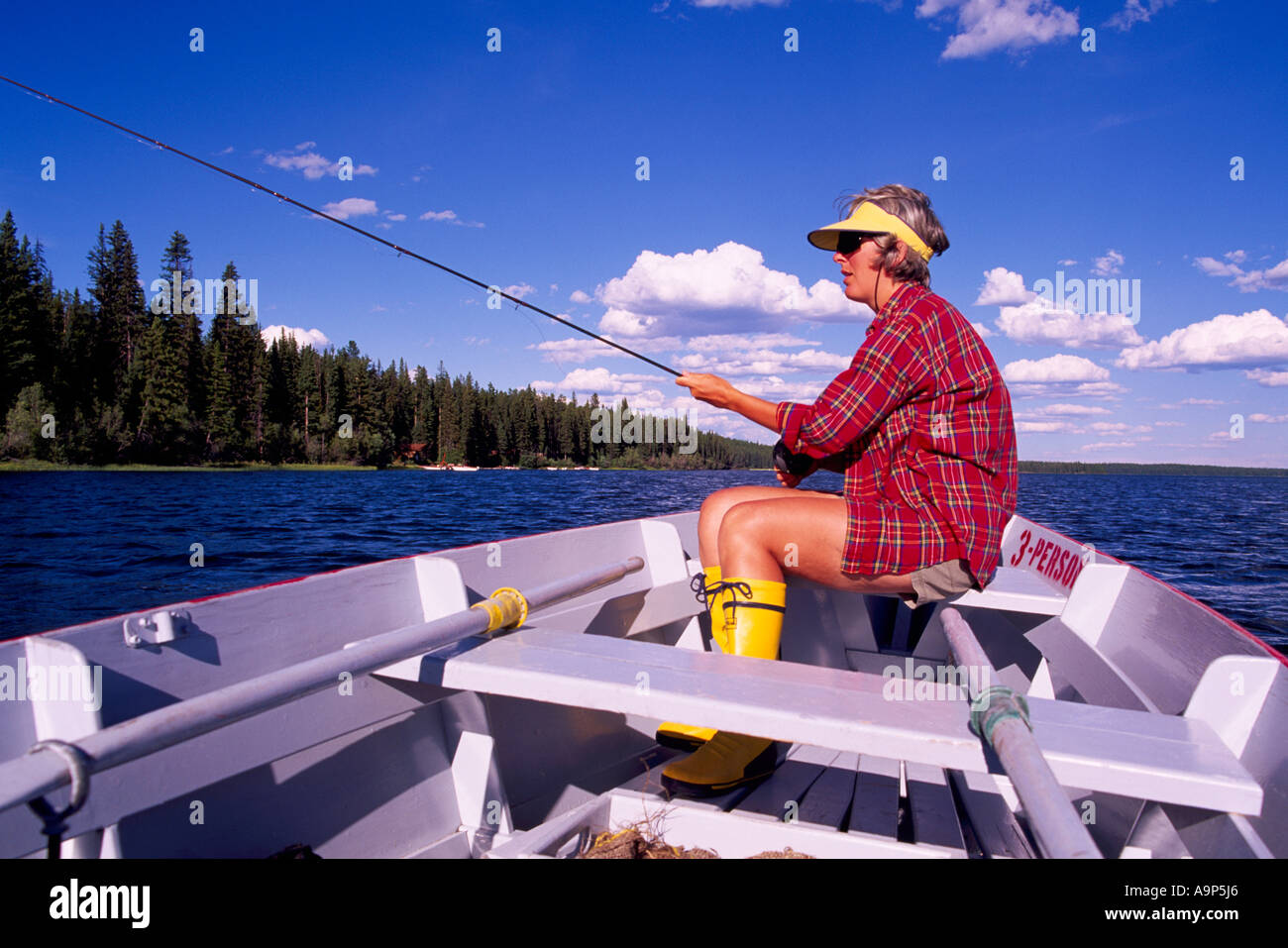 Fisherwoman fishing for Trout from a Rowboat on Hi Hium Lake, Cariboo Region, BC, British Columbia, Canada Stock Photo