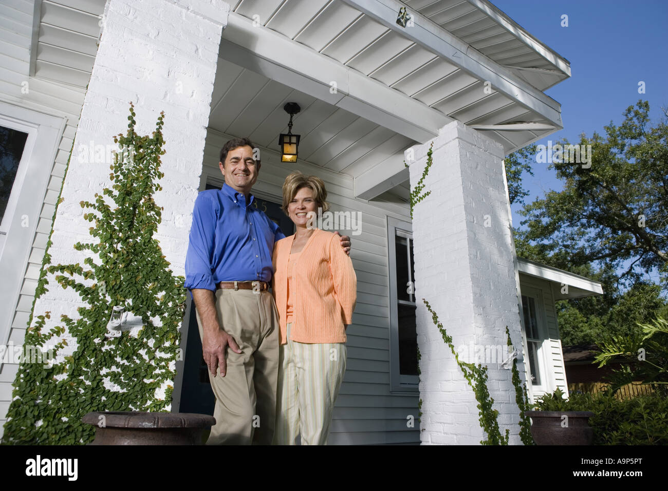 Portrait of a mature couple standing outside a house Stock Photo - Alamy
