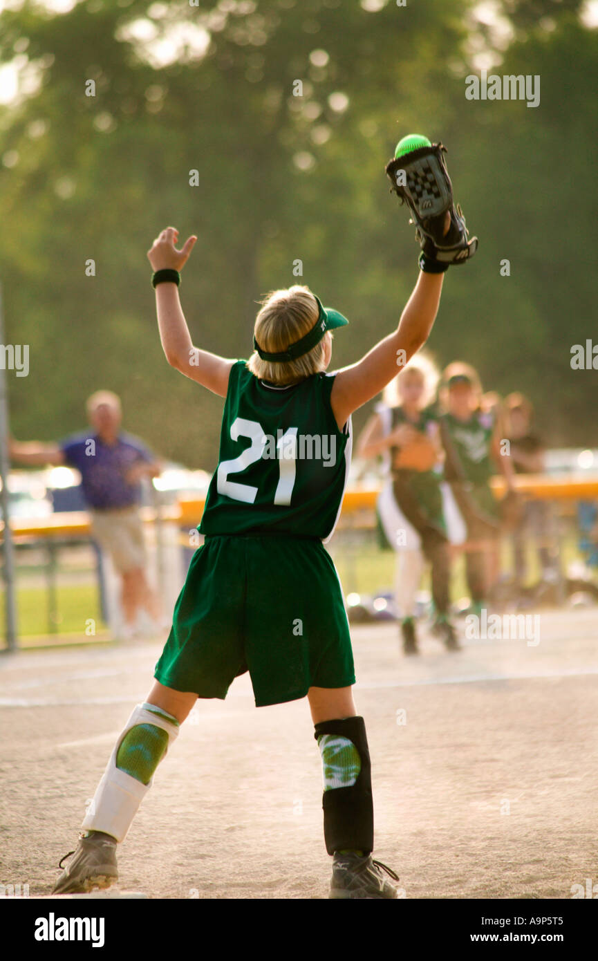 Girl in uniform catching softball Stock Photo