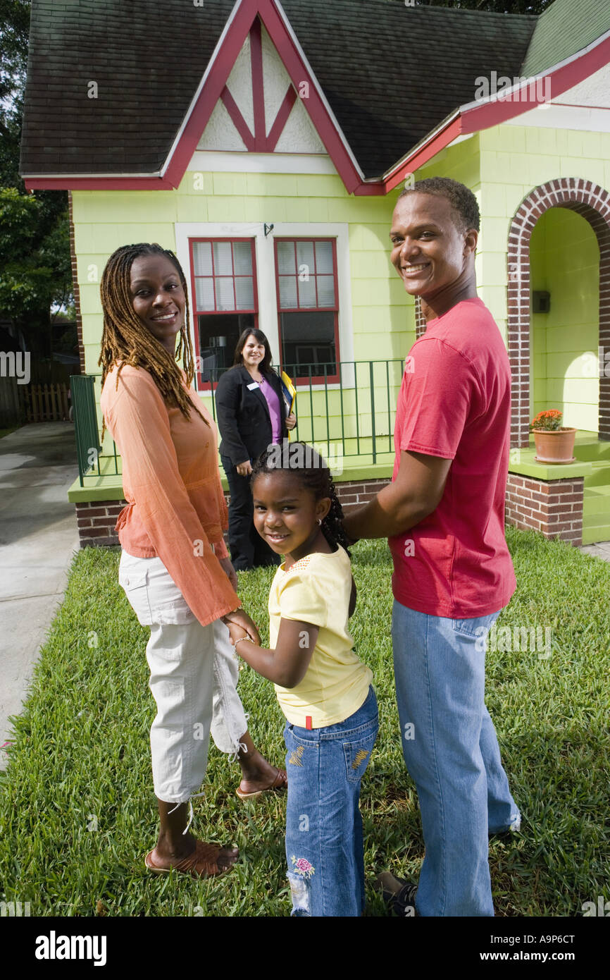 Portrait of family standing outside house with real estate broker Stock ...